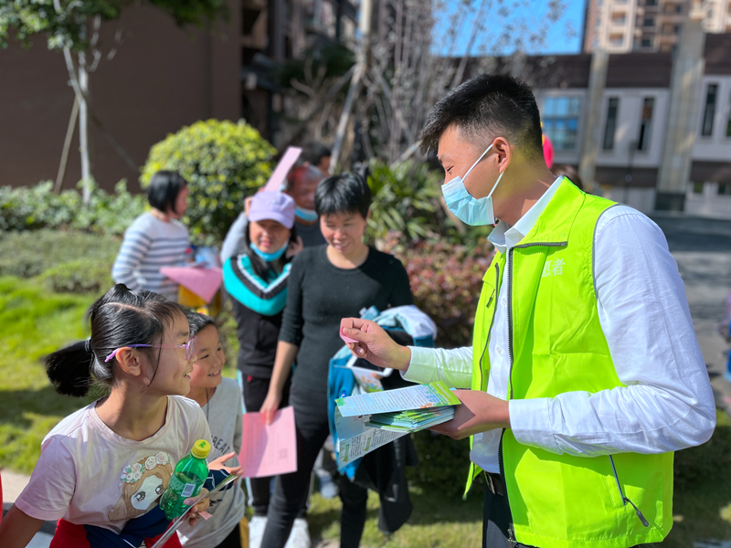 志愿者向居民介紹垃圾分類的方法.JPG